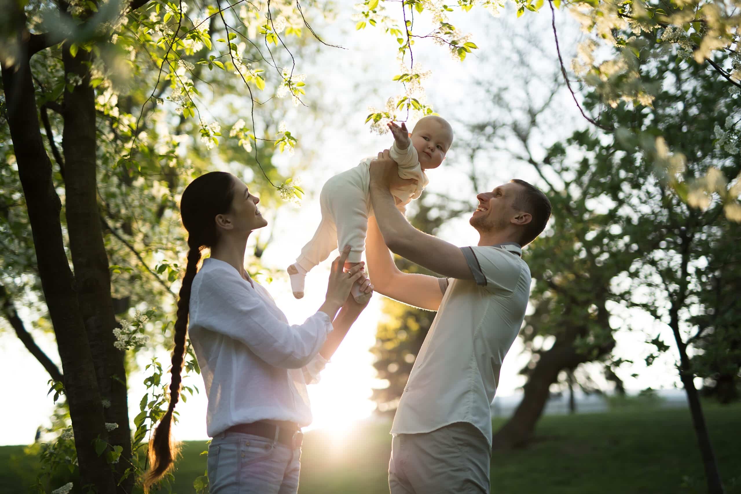 happy man and woman playing with baby outdoors 2022 02 16 20 06 32 utc scaled